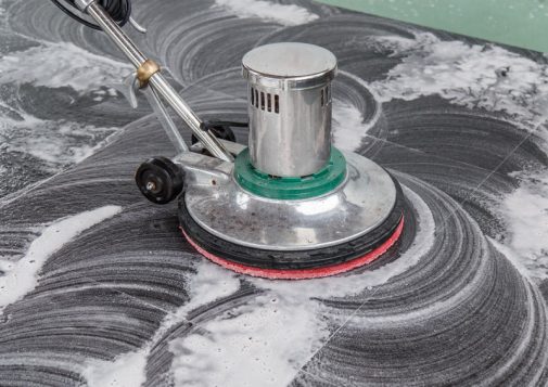 Thai people cleaning black granite floor with machine and chemical
